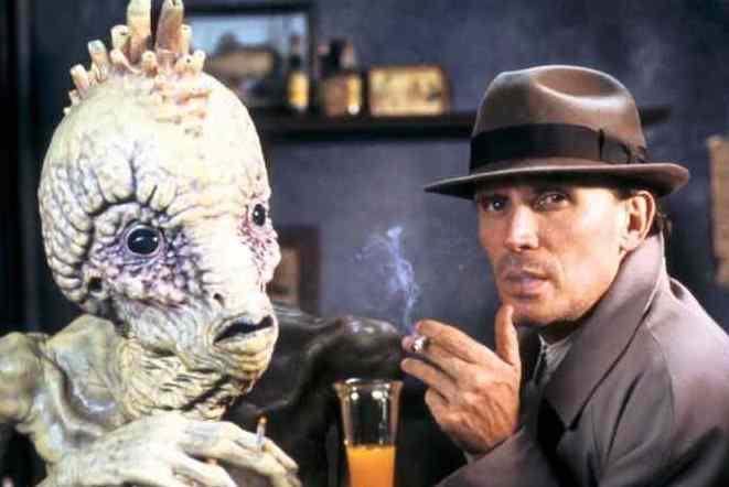 A man is smoking with a calm expression on his face. He is next to a monstrous creature.