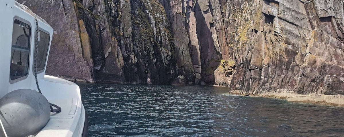 Side of boat facing sea cliffs