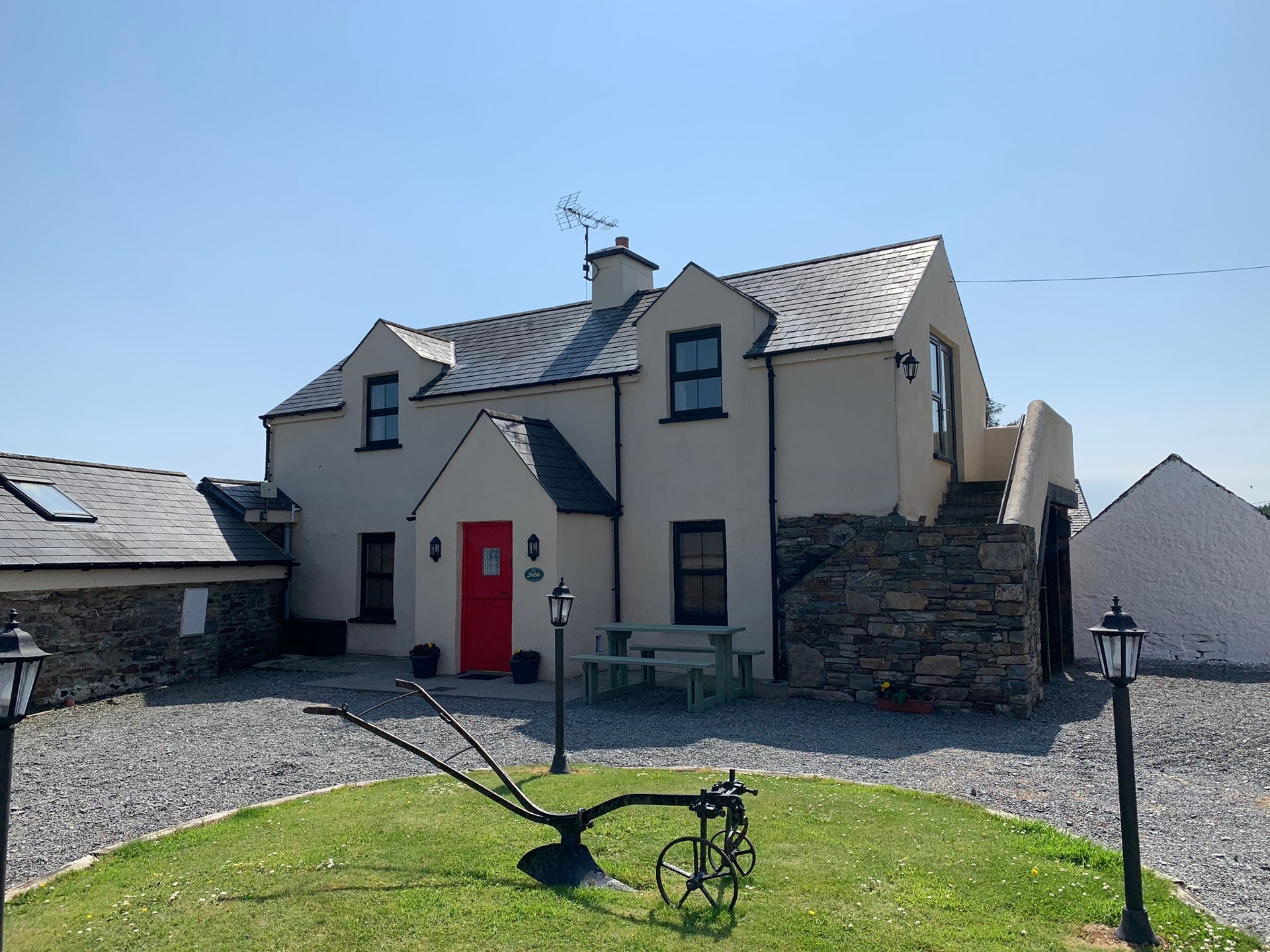 Farmhouse with gravel driveway.
