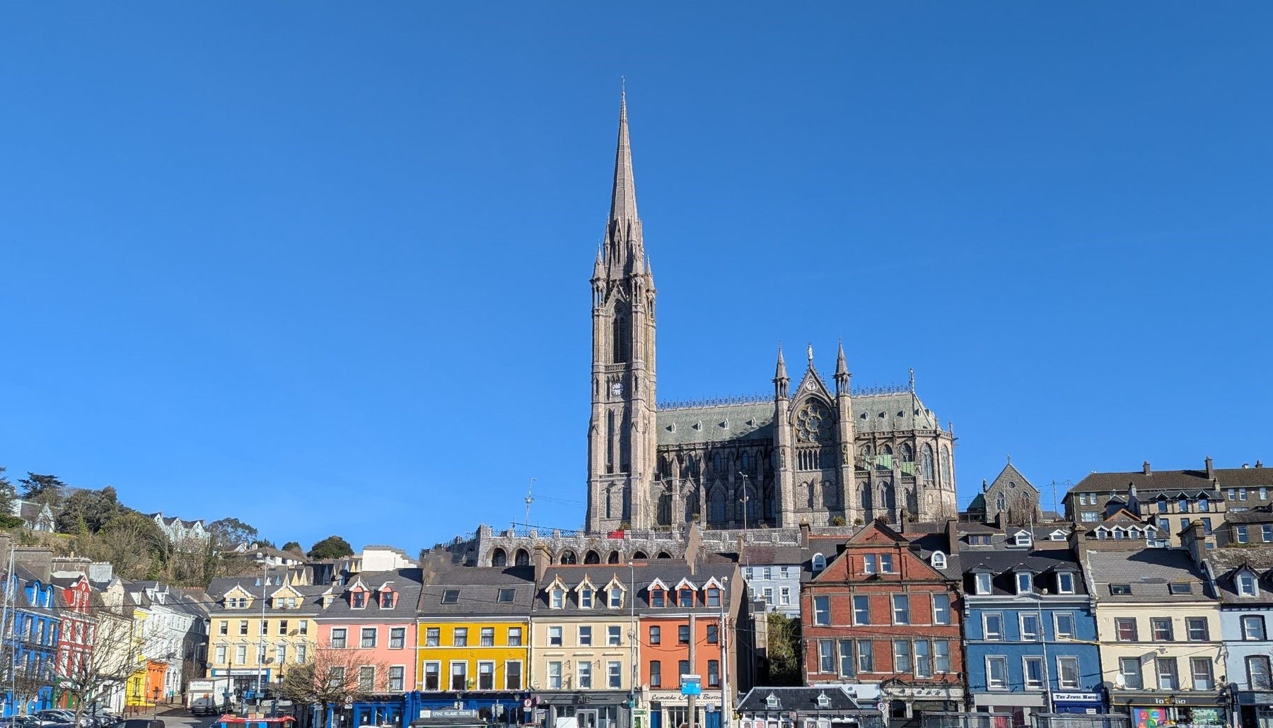 Cathedral behind colourful houses with a blue sky above