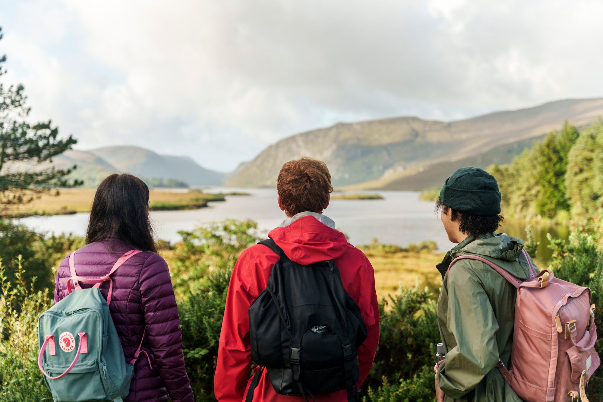 Three people looking out over the loughs at Glenveagh National Park in Letterkenny, County Donegal.