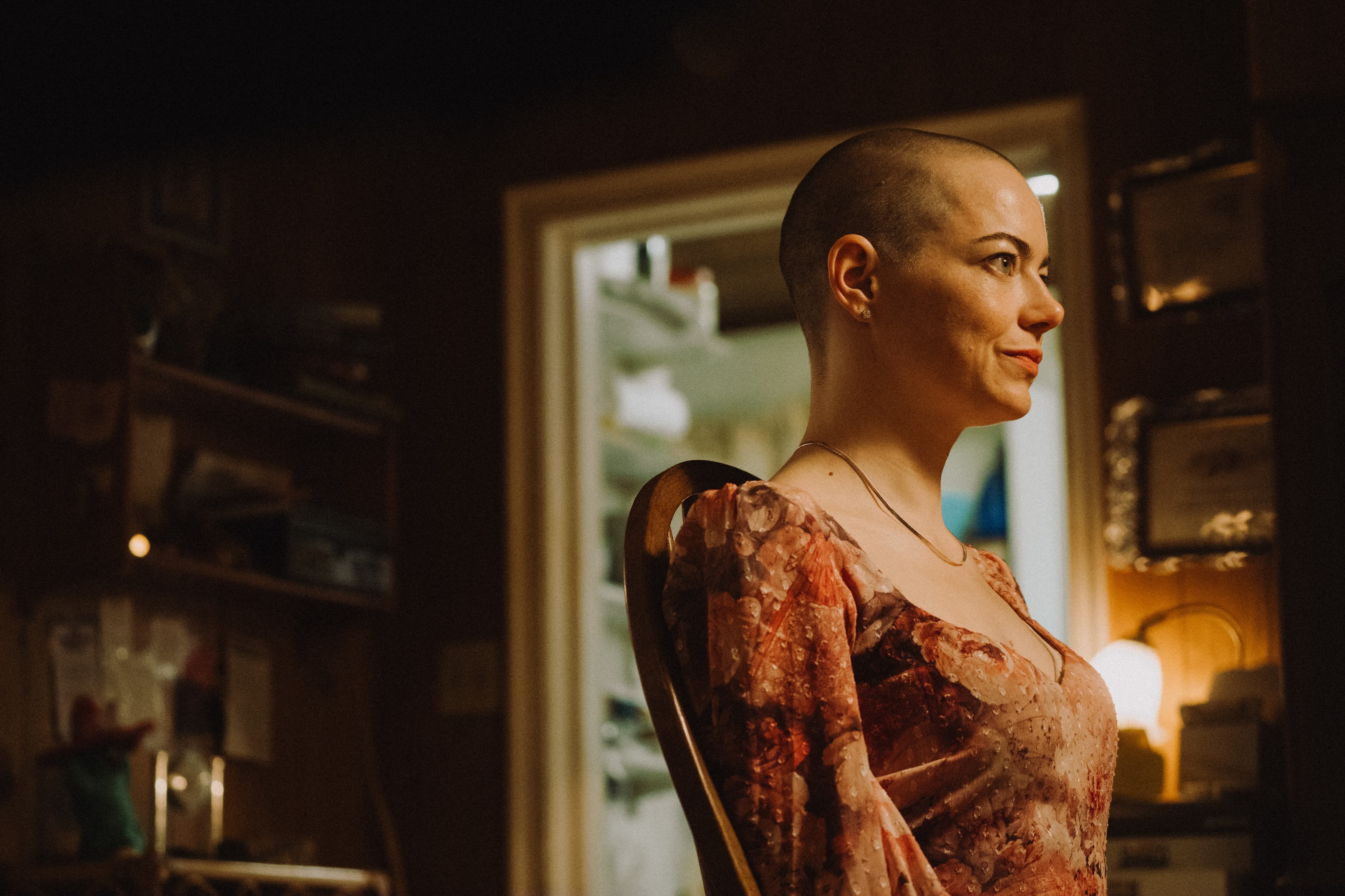 A woman with a shaved head.