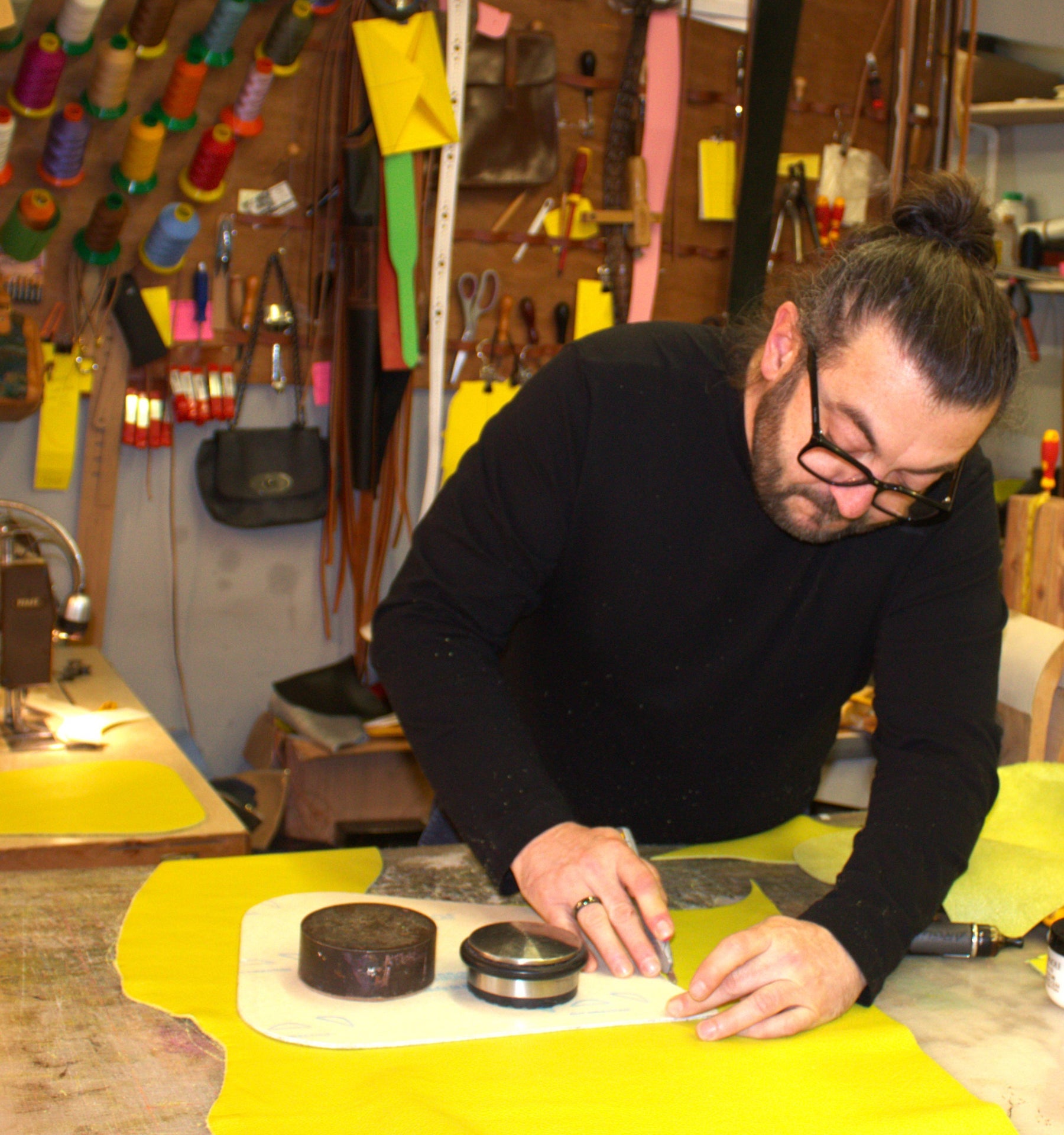 A man at a desk in a studio working on a design