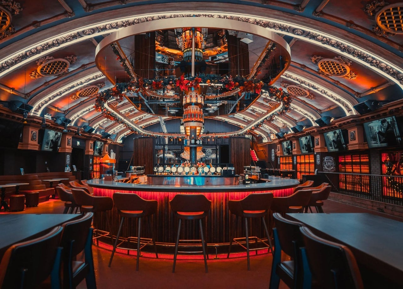 An illuminated circular bar featuring vaulted ceilings with architectural details