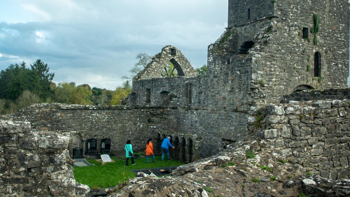 Three people exploring an ecclesiastical site