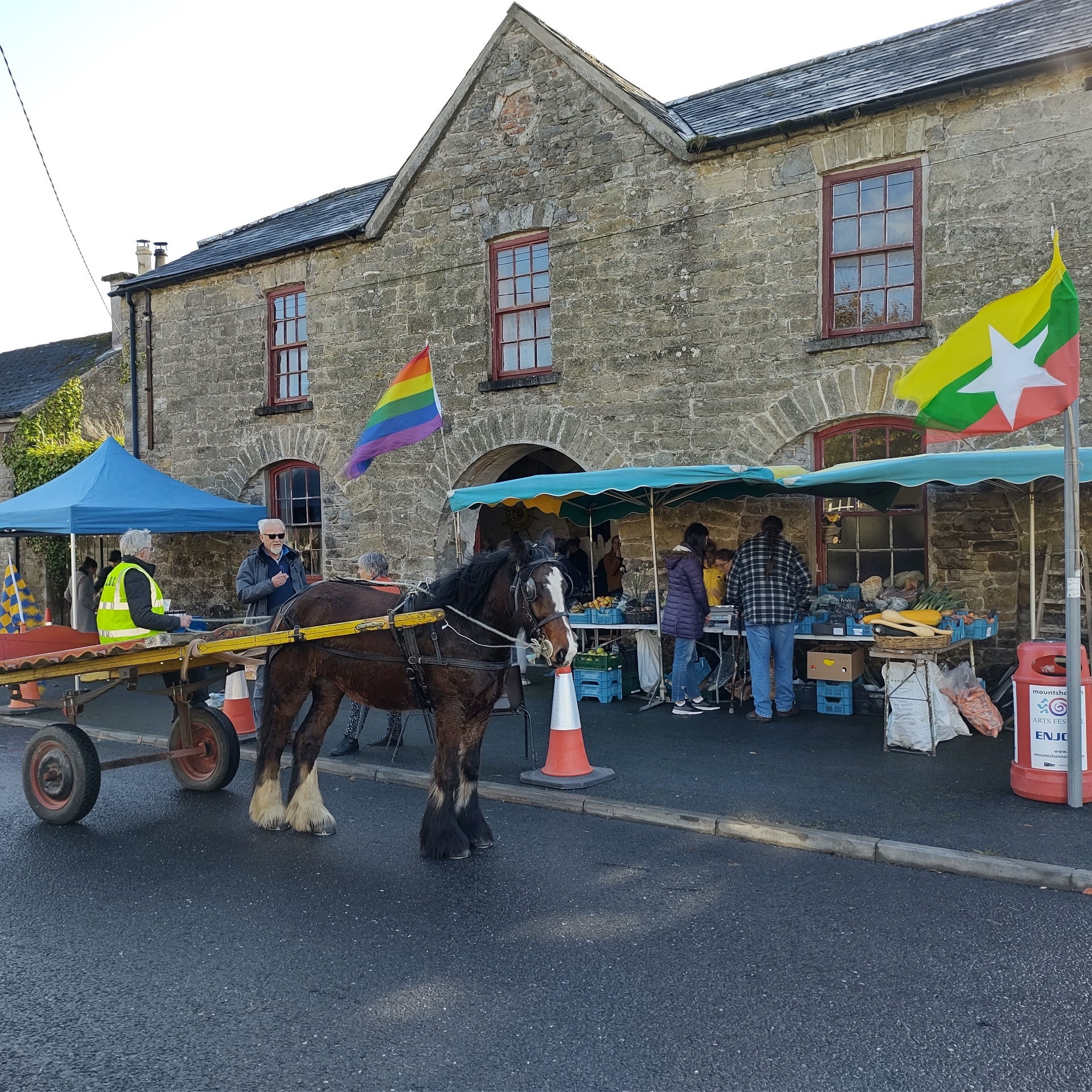 Stone building with two market stalls and a pony and cart outside