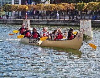A group together on larger canoe out on the river