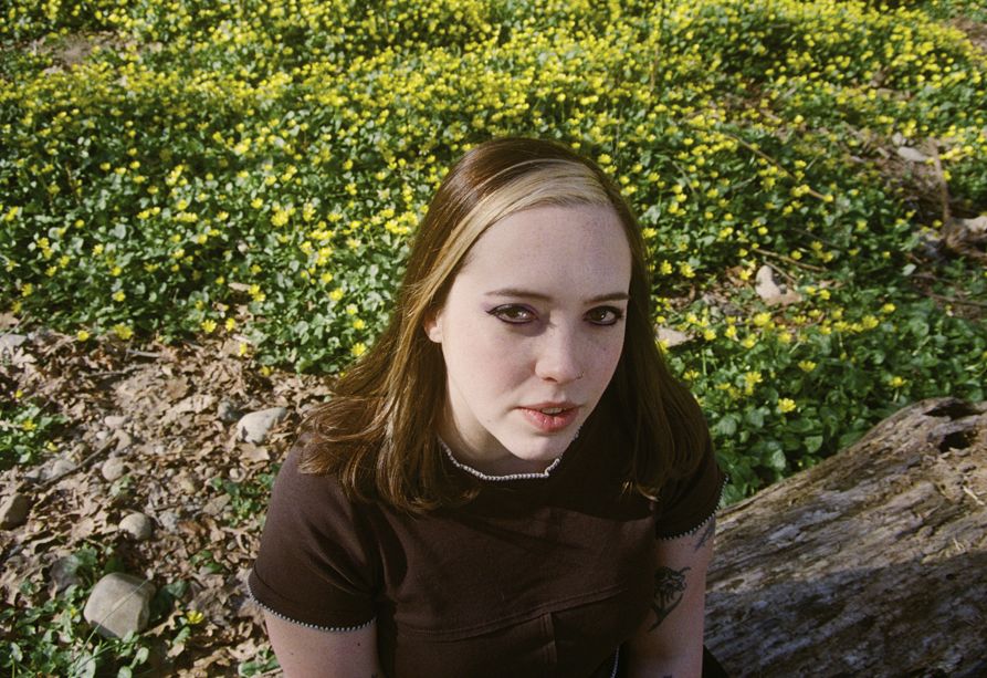 Looking slightly down at a woman in dark top outdoors.