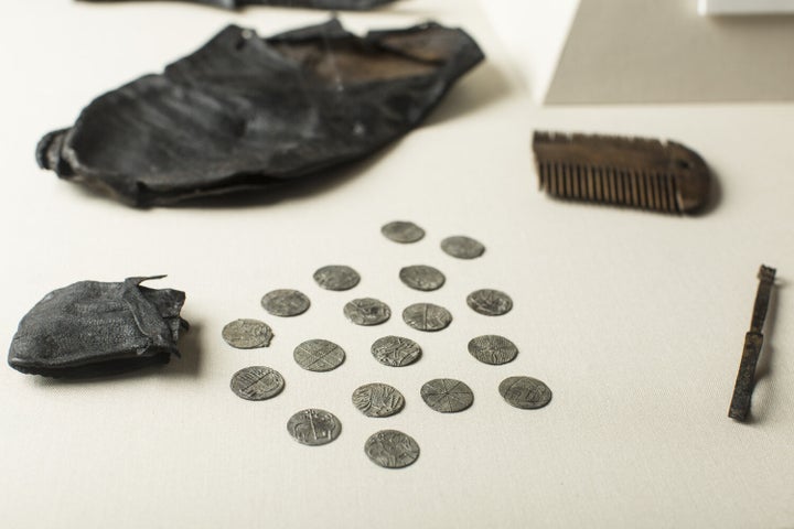 Viking coins spread over a tables from a leather pouch