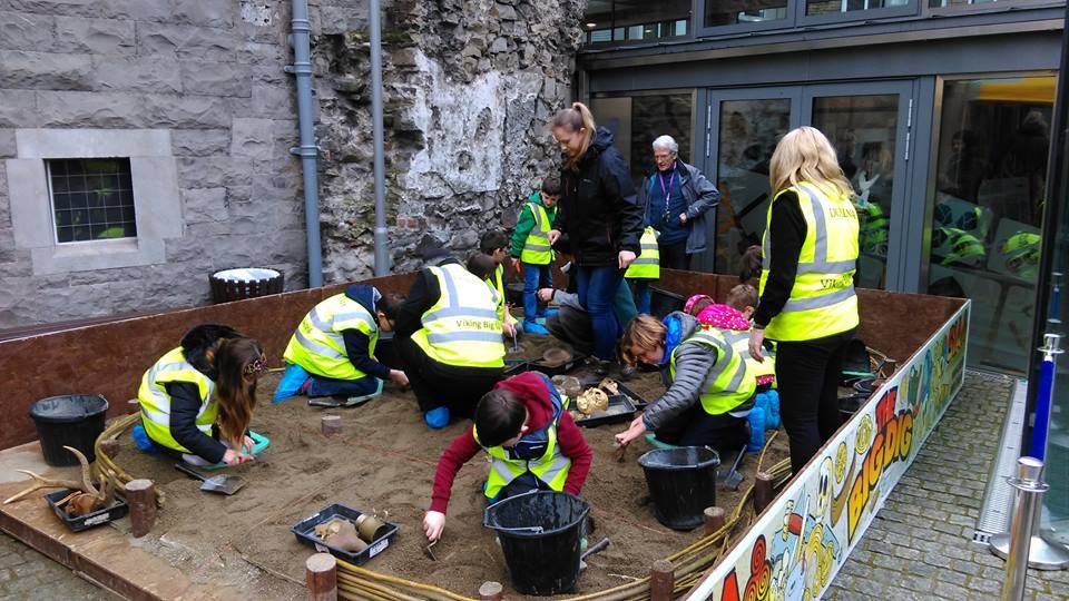 The Big Dig: A Viking Adventure for Kids, children digging with buckets in a large sand pit