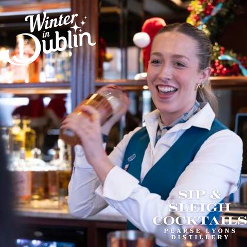 A smiling bartender is shaking a cocktail maker.