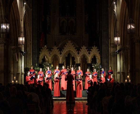 Christmas with Christ Church Cathedral choir, dressed in long red gowns standing in front of an alter