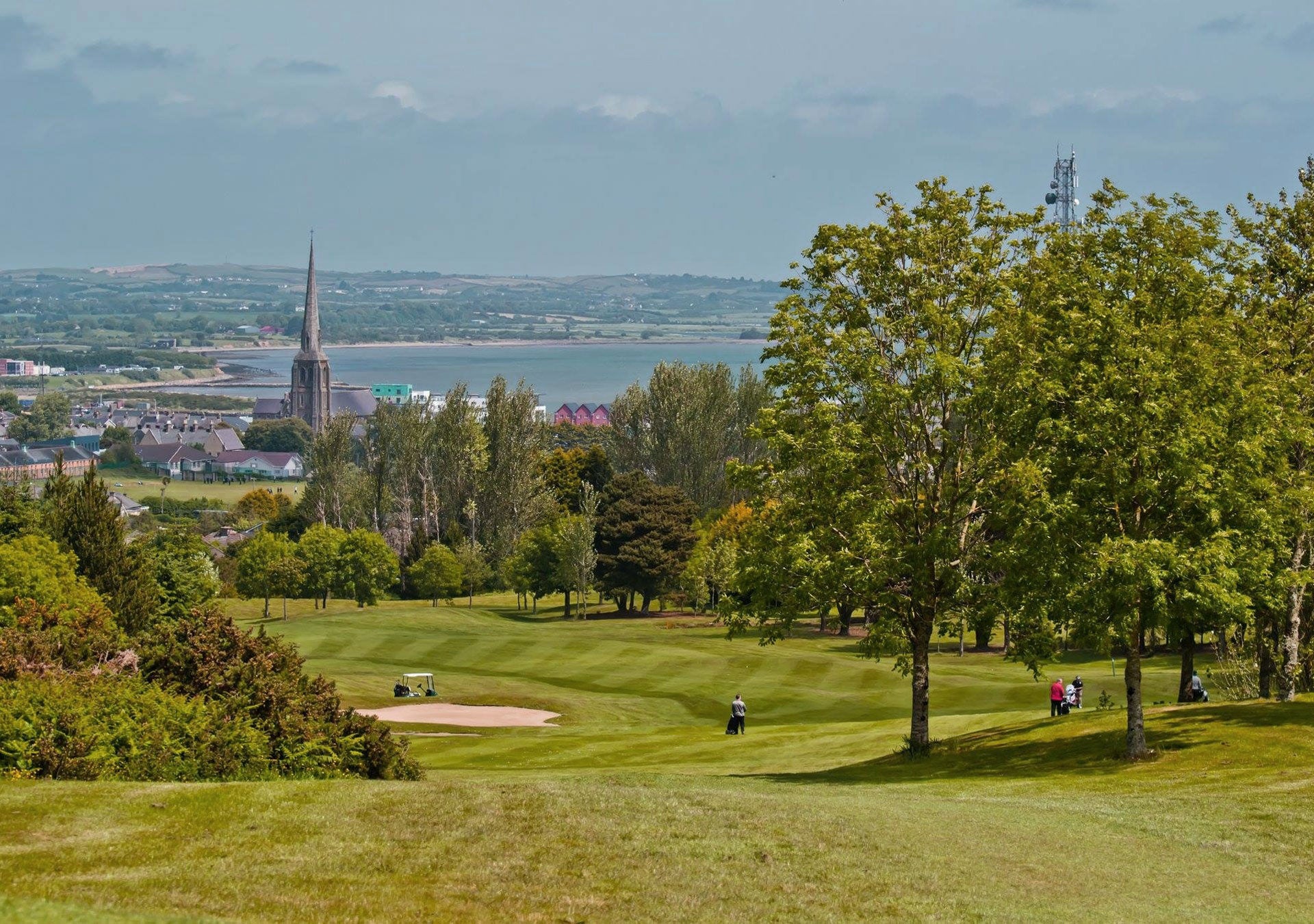 Wexford Golf Club view of a golf green with a church and the harbour in the background
