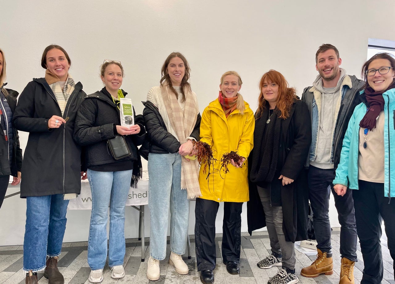 A group of people posing with seaweed and seaweed products