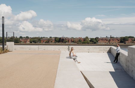 A large cement and brick open area with a partial coastal view
