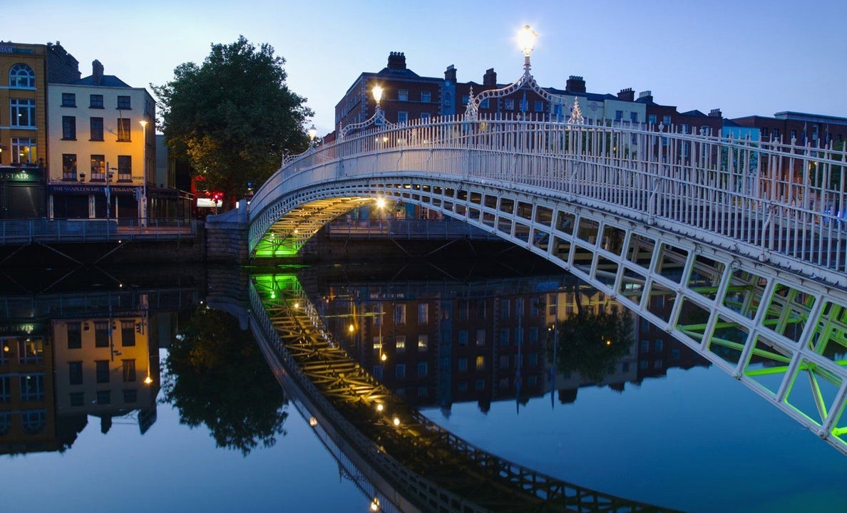 A bridge spanning a river in a city at dusk