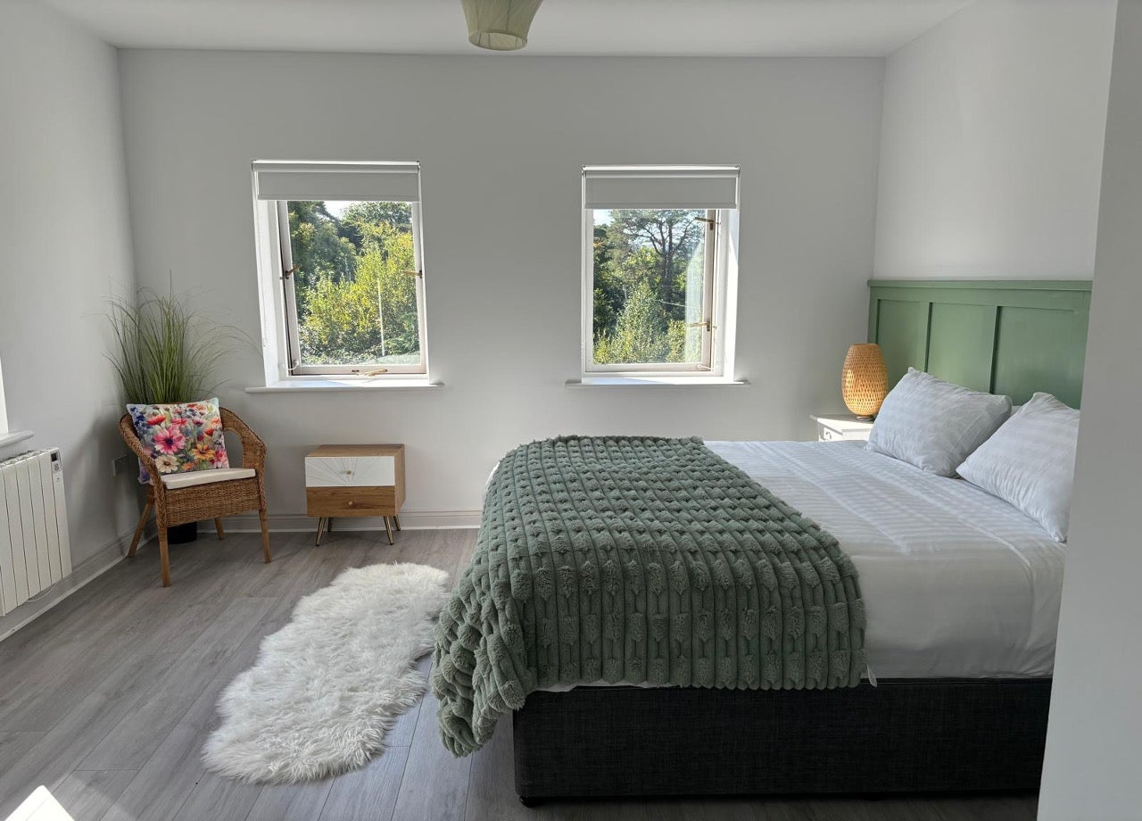 King bed with white and green sheets