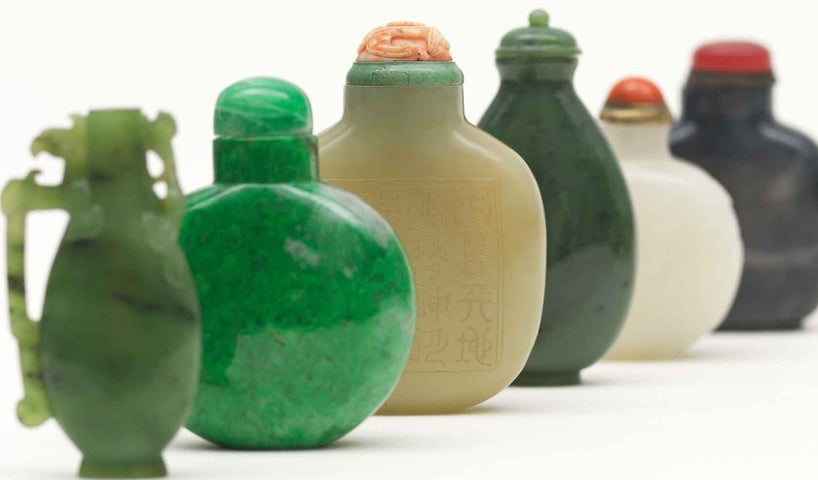 Up close view of line of small different coloured ceramic vessels