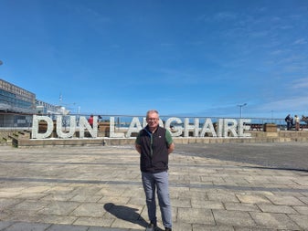 A tour guide posed at the Dun Laoghaire place name sculpture