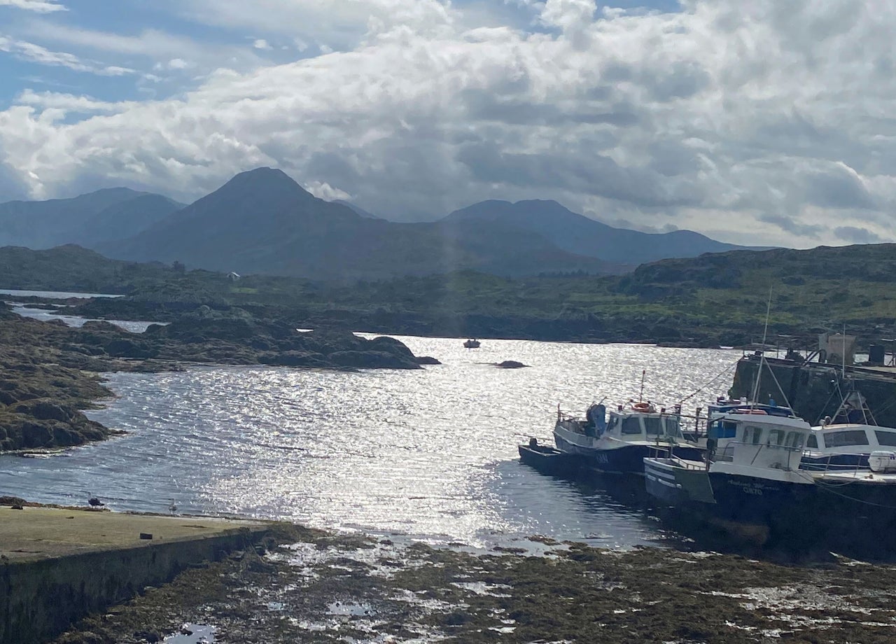 Boats in a small harbour with Connemara mountains in the background