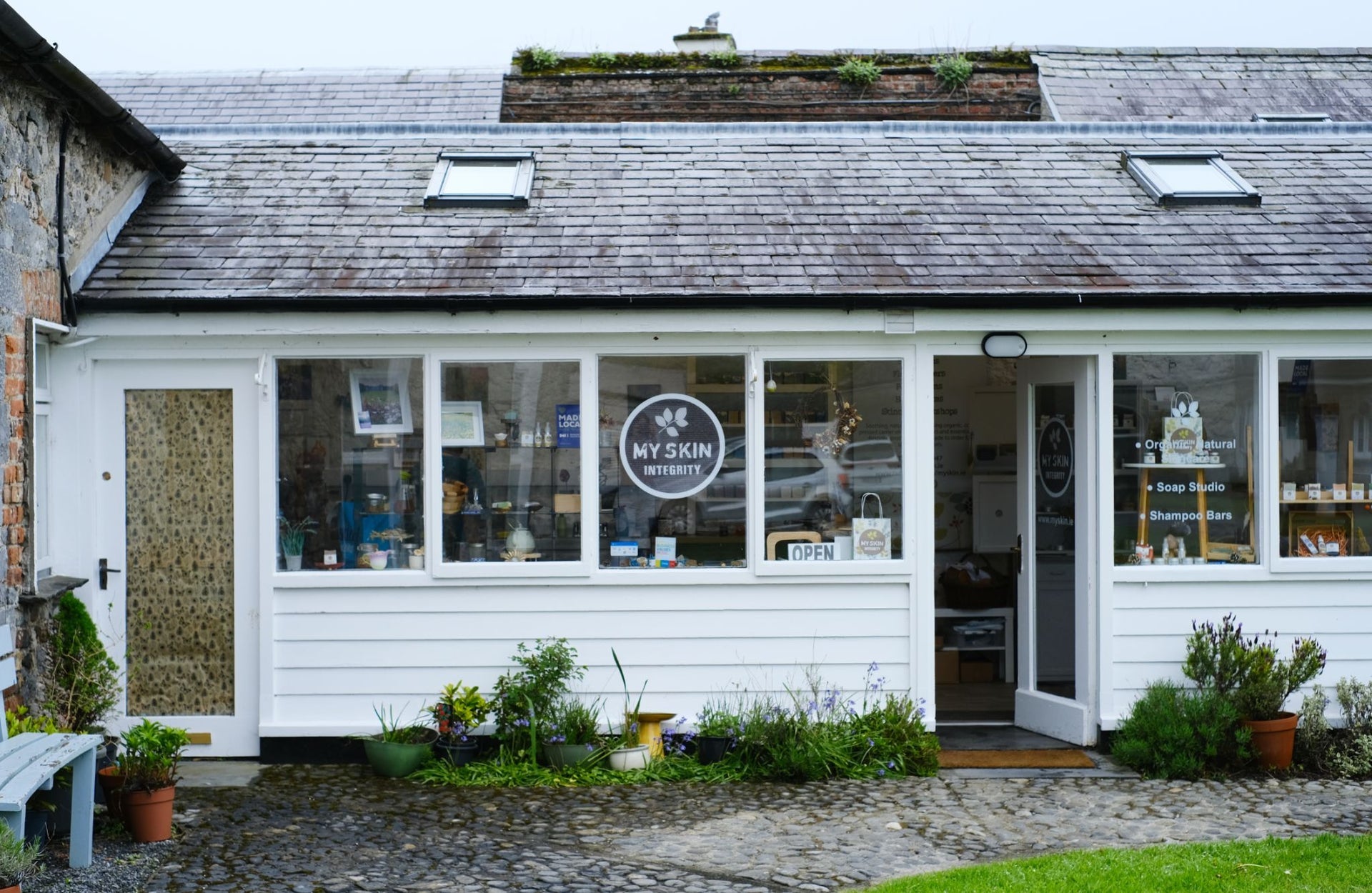 A white shed like structure converted into a retail and workshop space
