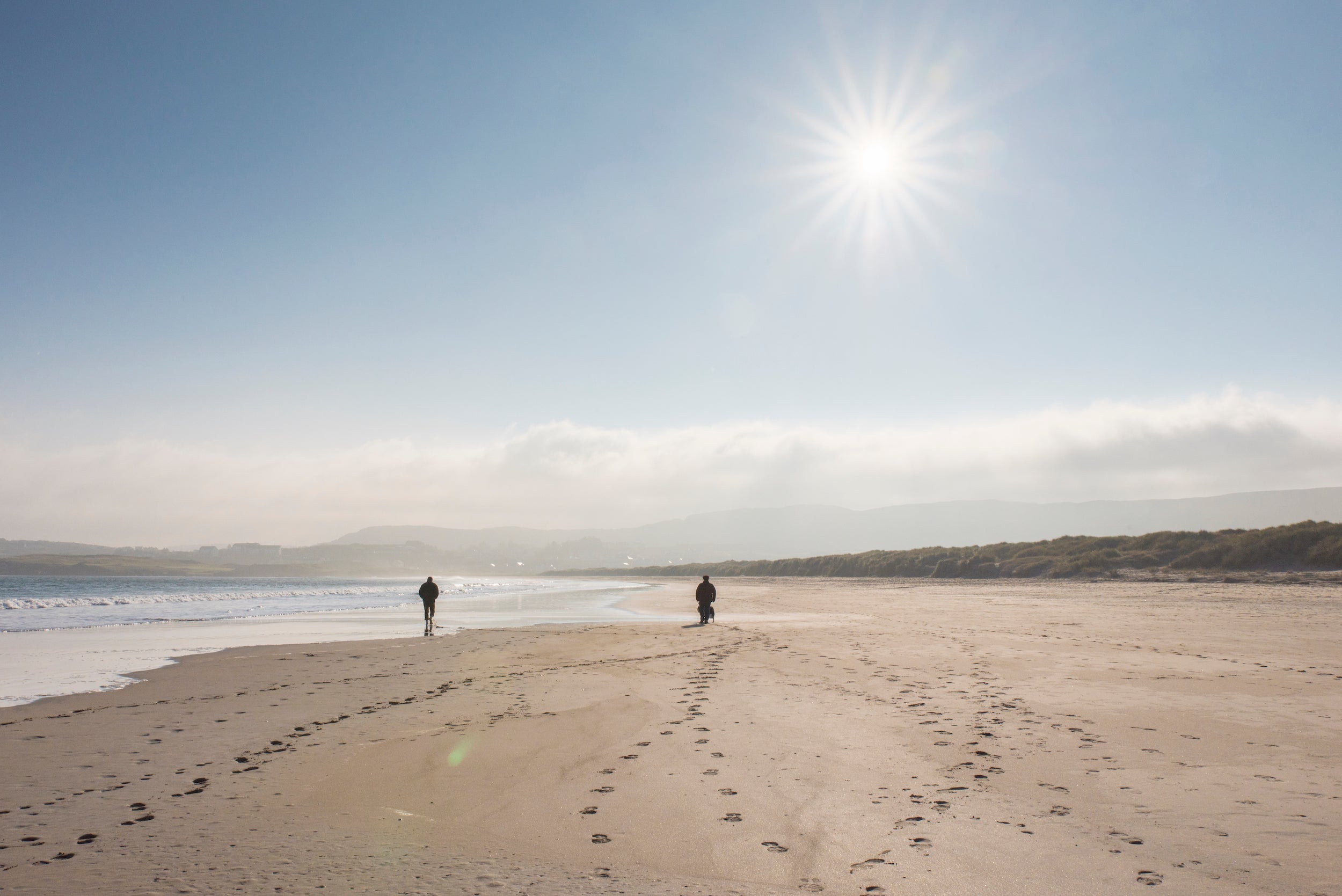 Two people walking on Killahoey Beach in Dunfanaghy, County Donegal