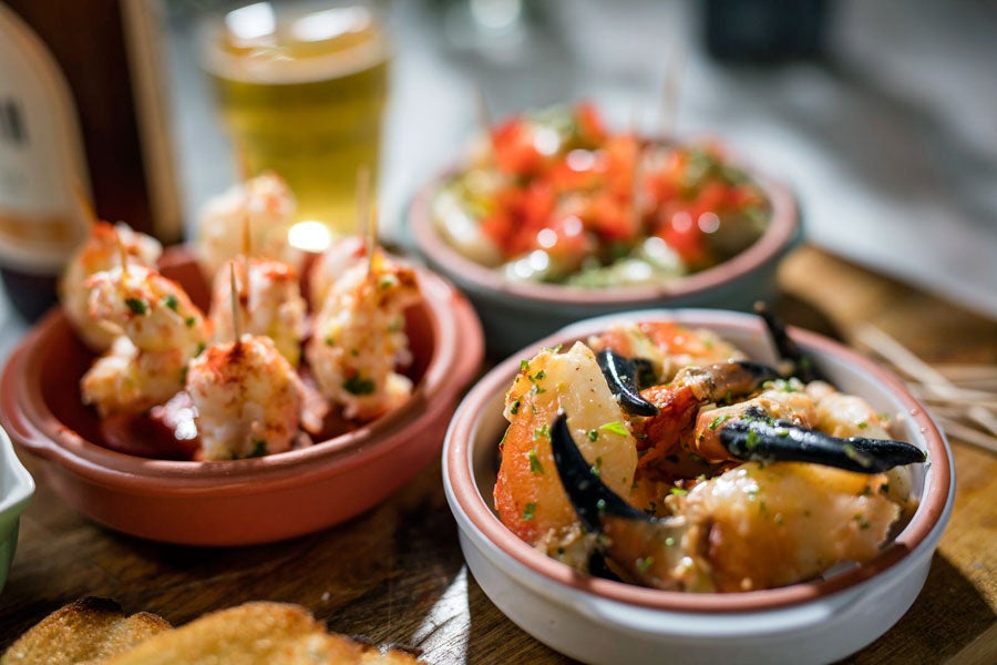 A display of sea food dishes including crab claws and prawns