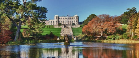 Historic mansion on a hill with a pond
