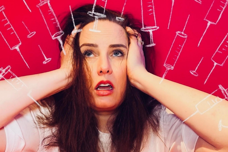 A woman looking upwards in despair with her hands either side of her head.