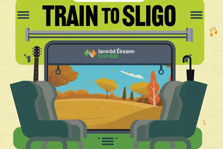 the image depicts the inside of a train carriage, there are 2 rows of seats infront of a window facing each other, behind one of the seats is a guitar and there is an umbrella behind the seat opposite, outside the window are trees