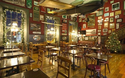 The interior of a restaurant with tables and chairs decorated for Christmas