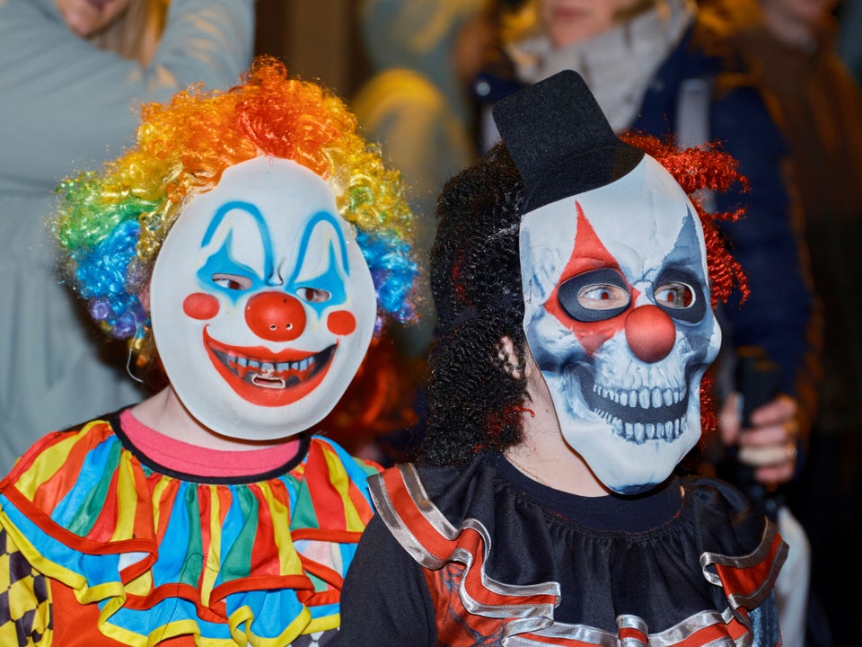 Children in vividly painted clown and skull masks at a Samhain (or Hallowe'en) Festival, one of Ireland's traditional autumn celebrations marking the turn of the Celtic year.