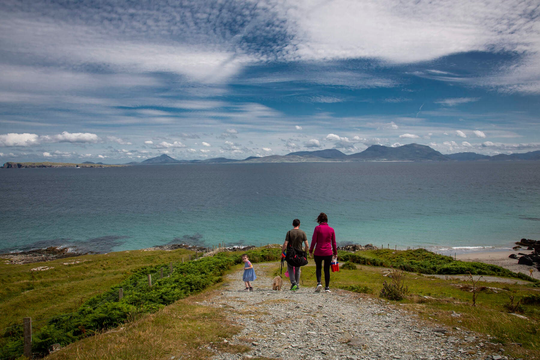 Family on a path to the sea with dramatic sky