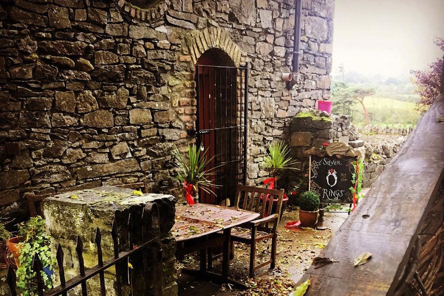 Old stone building and courtyard with a table and colourful plants in Rathcormac Craft Village in Branley's Yard