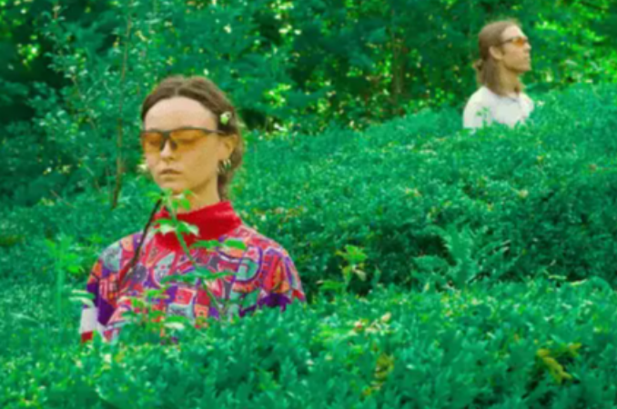 A photo of Sei Green standing in middle of hedges