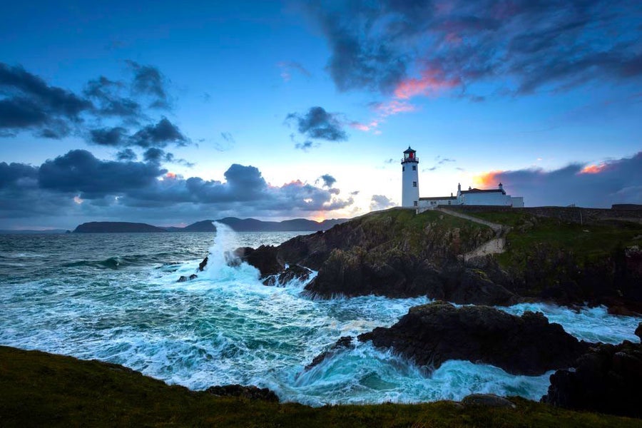 Fanad Lighthouse at sunset with foaming sea in foreground