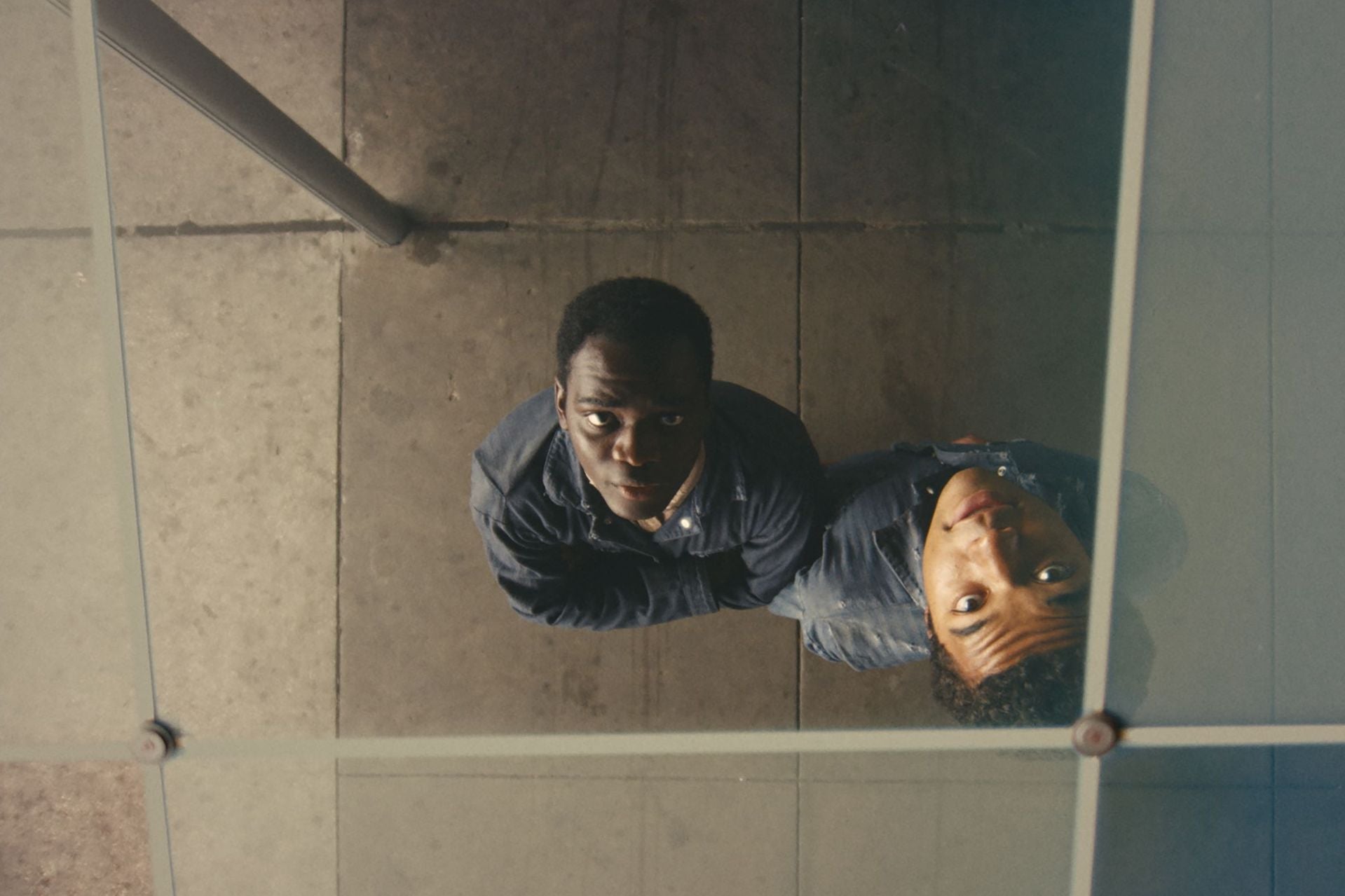 Two boys are looking up through a skylight.