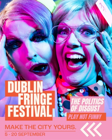 Two drag queens pose side-by-side, holding each other's faces and smiling into the camera. They wear sharp blonde wigs and colourful make-up. The queen on the right wears glasses. Dublin Fringe Festival's logo is in the bottom-left corner.