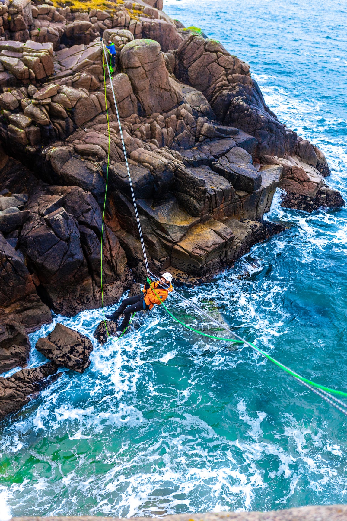 A man Tyrolean Traversing on Cruit Island in County Donegal