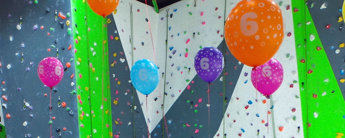 A variety of multi coloured balloons in front of the climbing wall