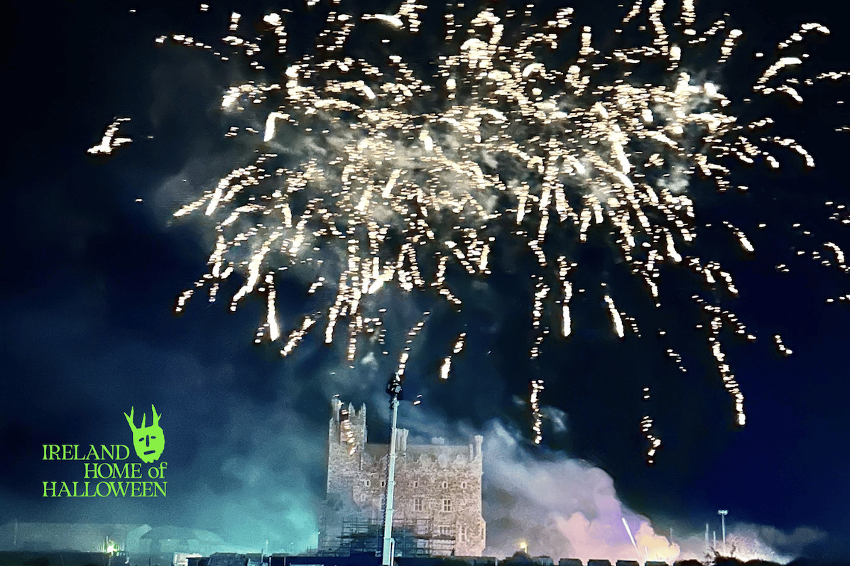 White fireworks at night exploding over a castle below