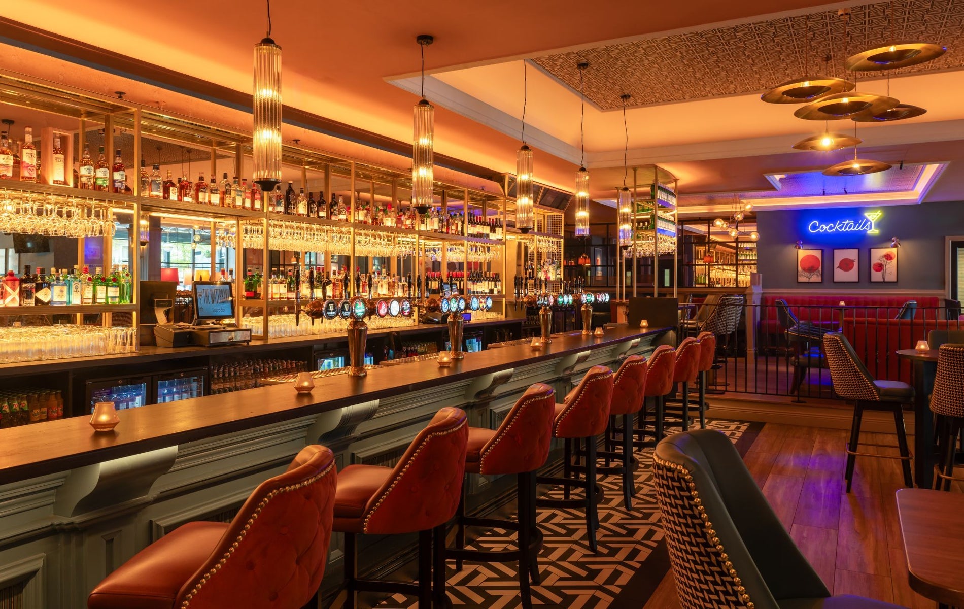 The interior of a bar with seats lined up along the counter