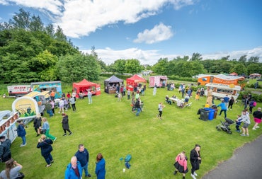 Aerial image of people in a park with market stalls all around