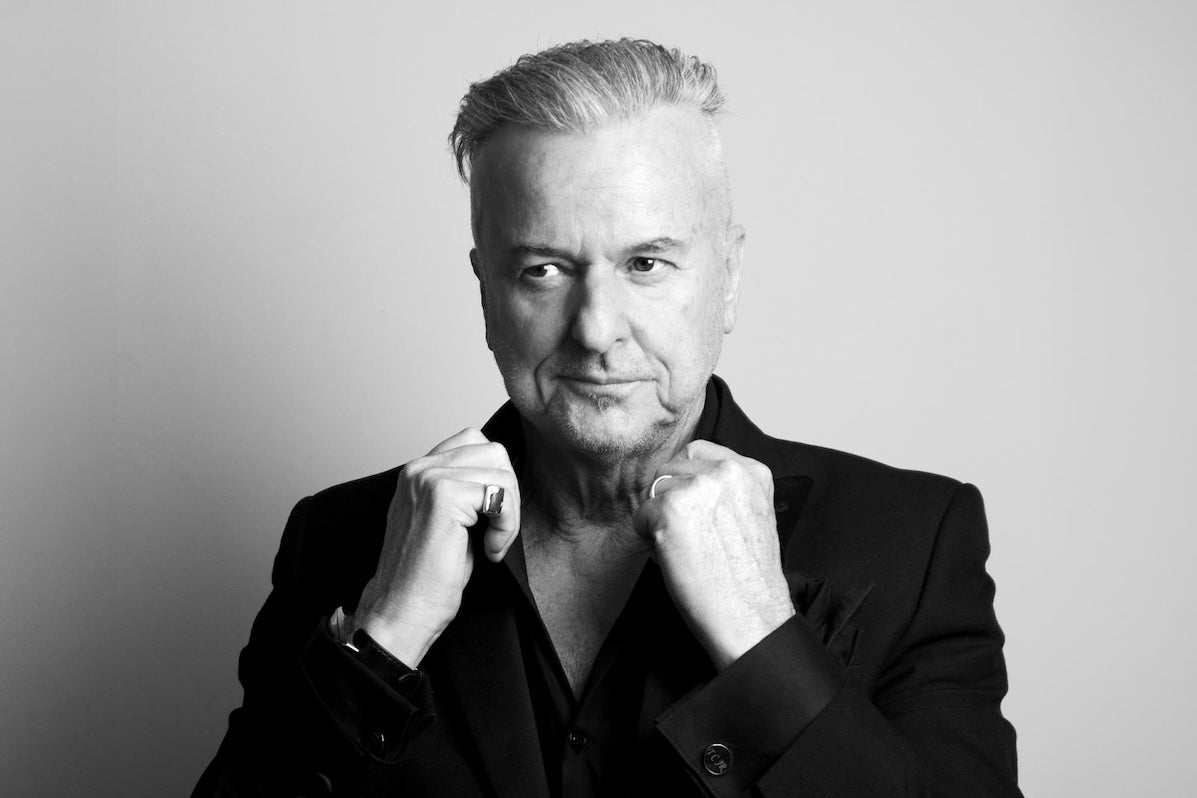 Black and white photo of man holding up the collar of his jacket.