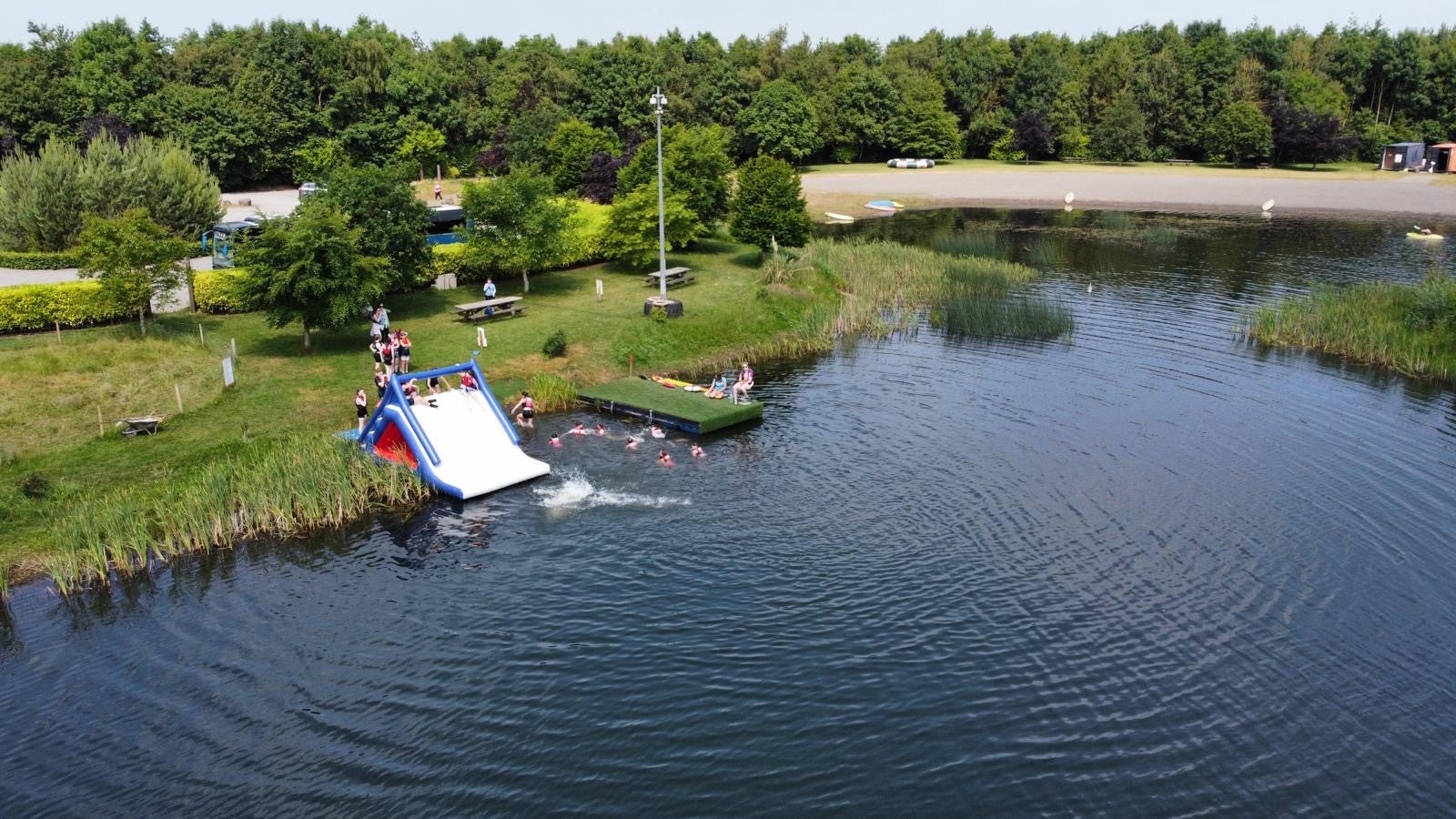 Children on an inflatable slide at a lake side