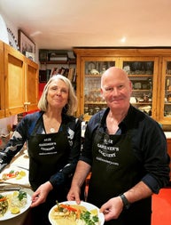 Two people in aprons posing with their dishes