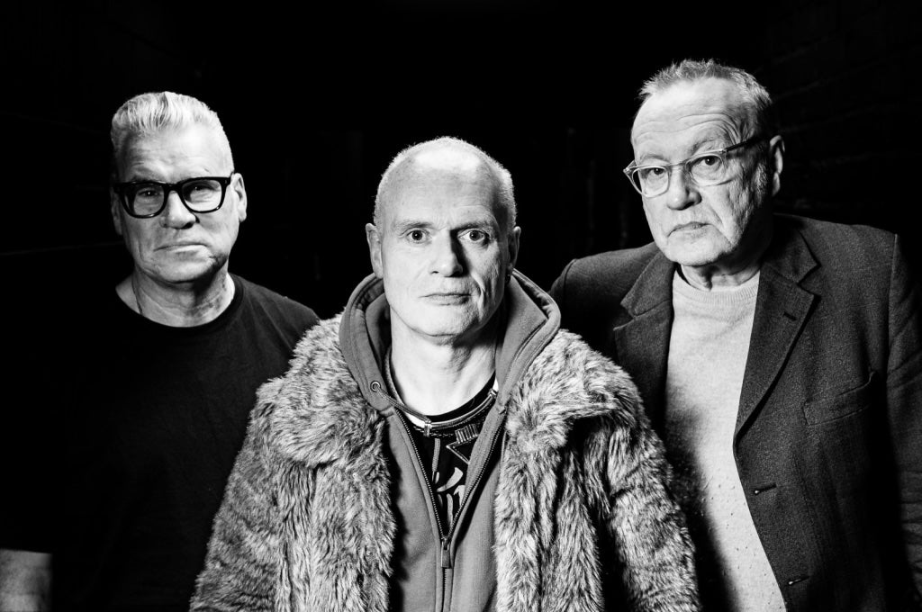 Black and white image of 3 older, unsmiling men.