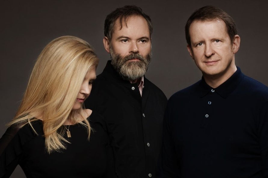 Group of 2 men and a woman, her face partially obscured by hair.