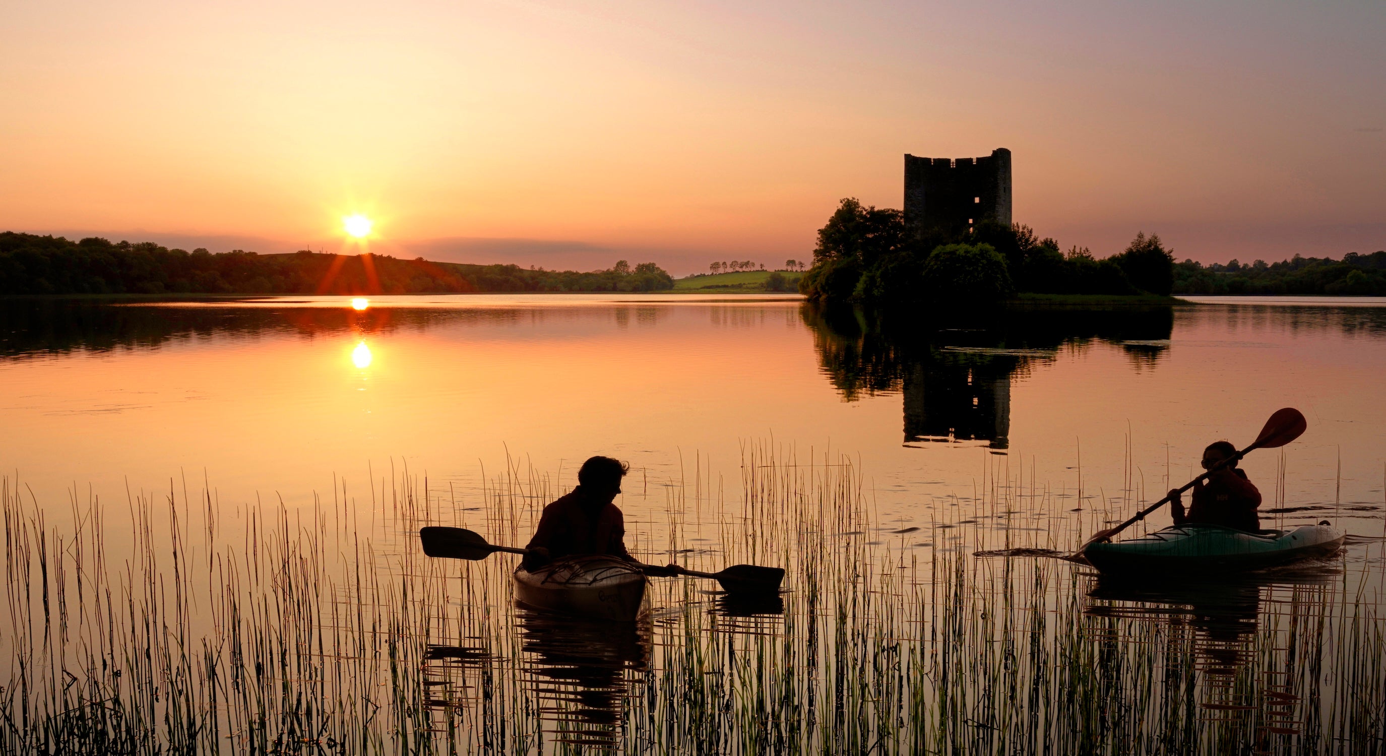 People kayaking past Cloughoughter Castle in Co Cavan