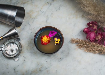 A soup bowl decorated with three flower heads in the soup
